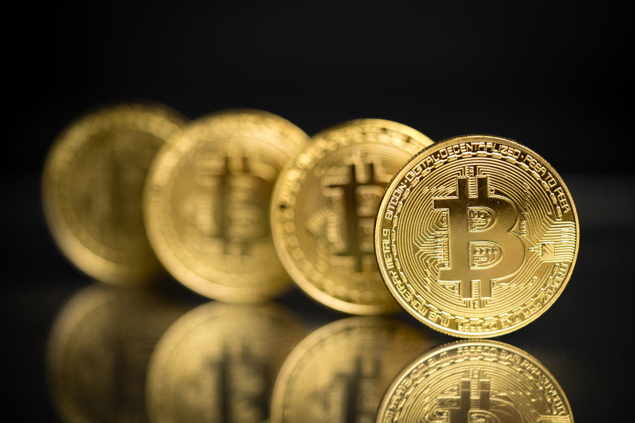 Philippines, August 25 - 2018: Row of gold plated Bitcoin physical form imitation as a decentralized digital currency which enables instand payment to anyone around the world. Original bitcoin software was invented by Satoshi Nakamoto and being used as open source licensing. This close up shot of bitcoin to symbolize bitcoin market, modern tech, crypto currency, finance, stock and trading over internet.
