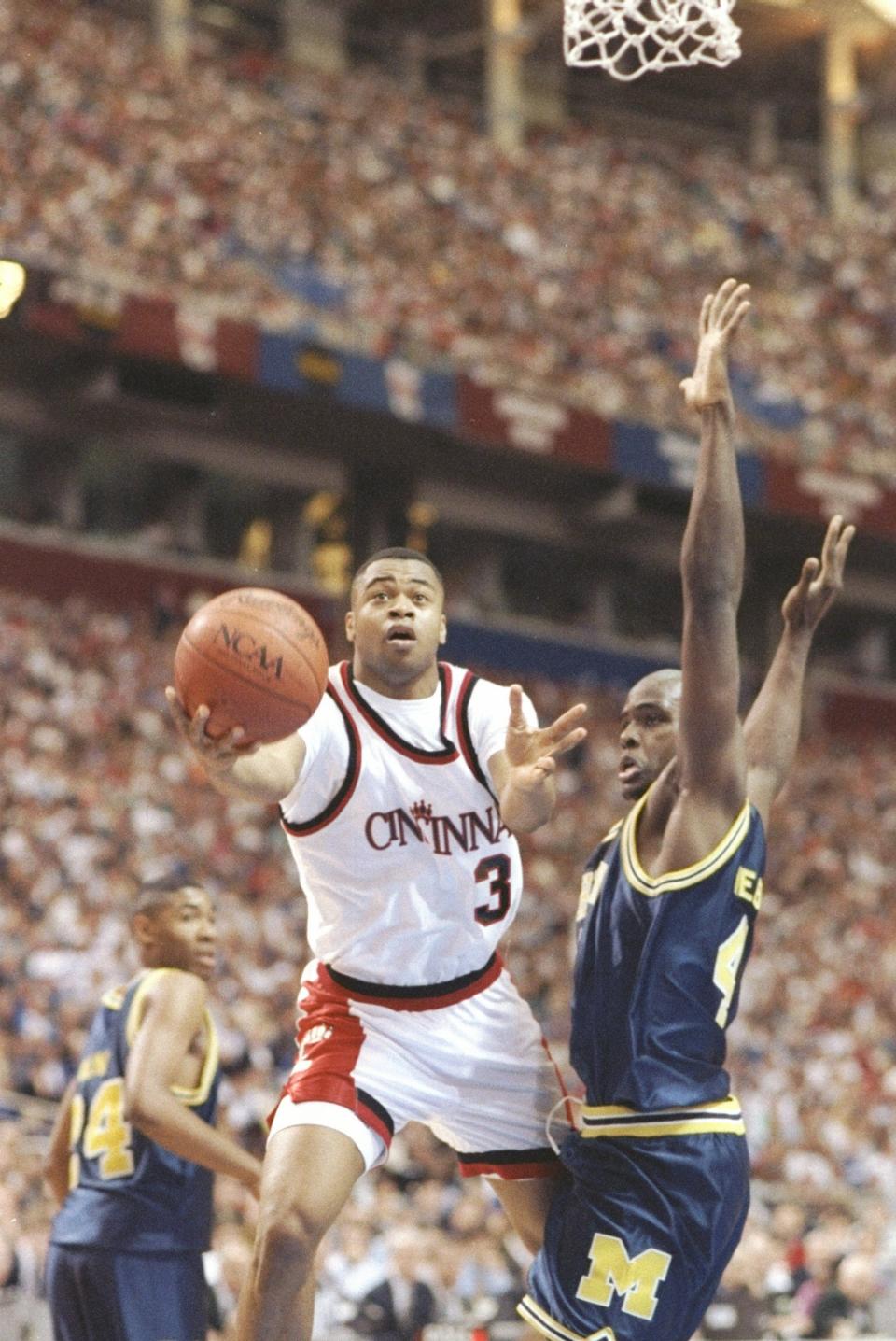 Forward Chris Webber of the Michigan Wolverines tries to stop Erik Martin of the Cincinnati Bearcats during a playoff game in Minneapolis, Minnesota, April 4, 1992.