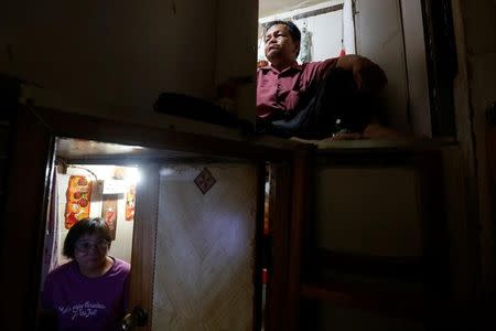 Unemployed Hong Kong residents Lam (R), 60, and Kitty Au, 63, rest inside their upper and lower decks partitioned units, or "coffin units", in Hong Kong, China October 31, 2016. REUTERS/Bobby Yip