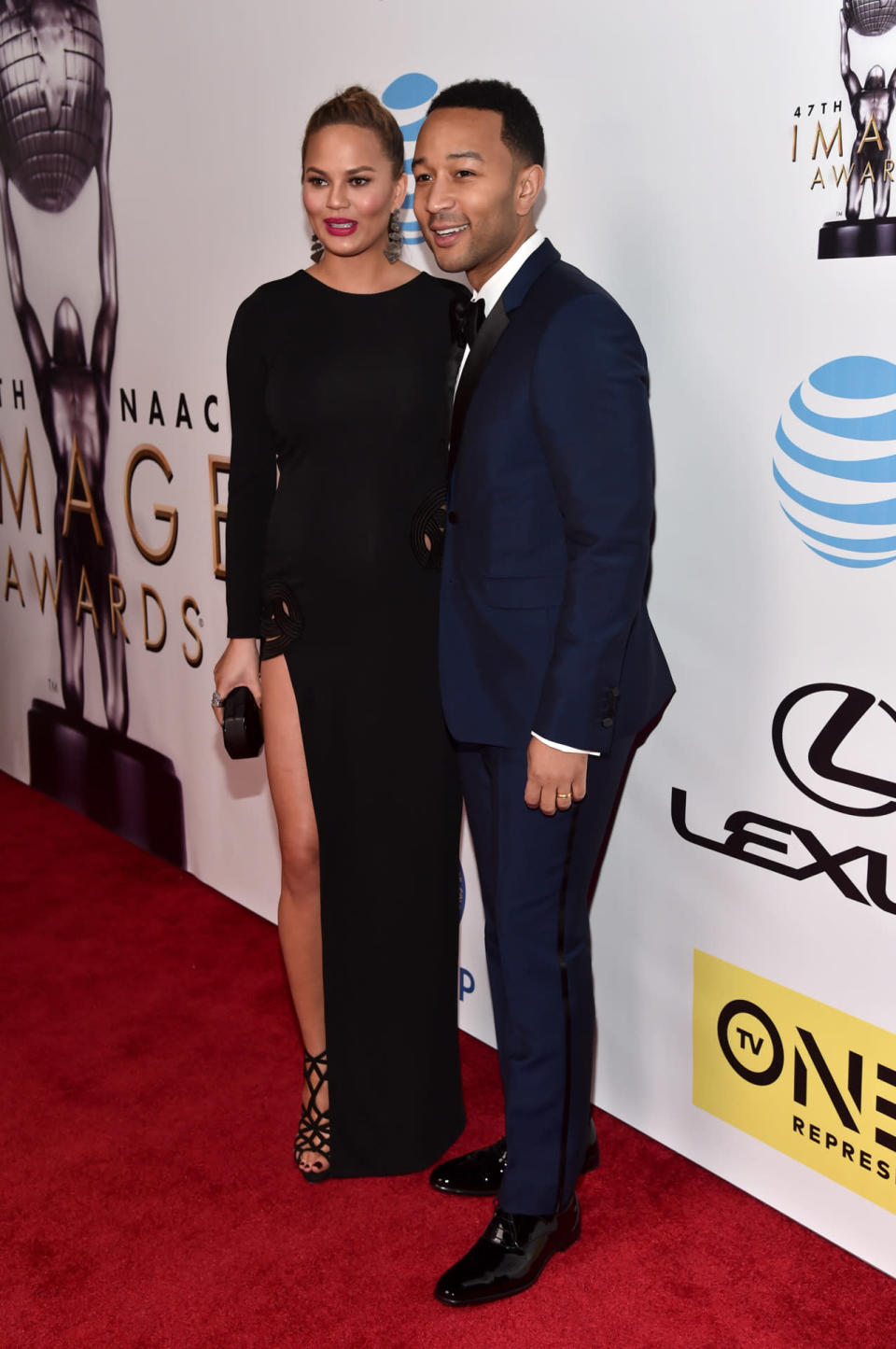 Chrissy Teigen in a long-sleeved black gown with her husband John Legend in a blue suit at the 47th NAACP Image Awards at Pasadena Civic Auditorium in Pasadena, California. 