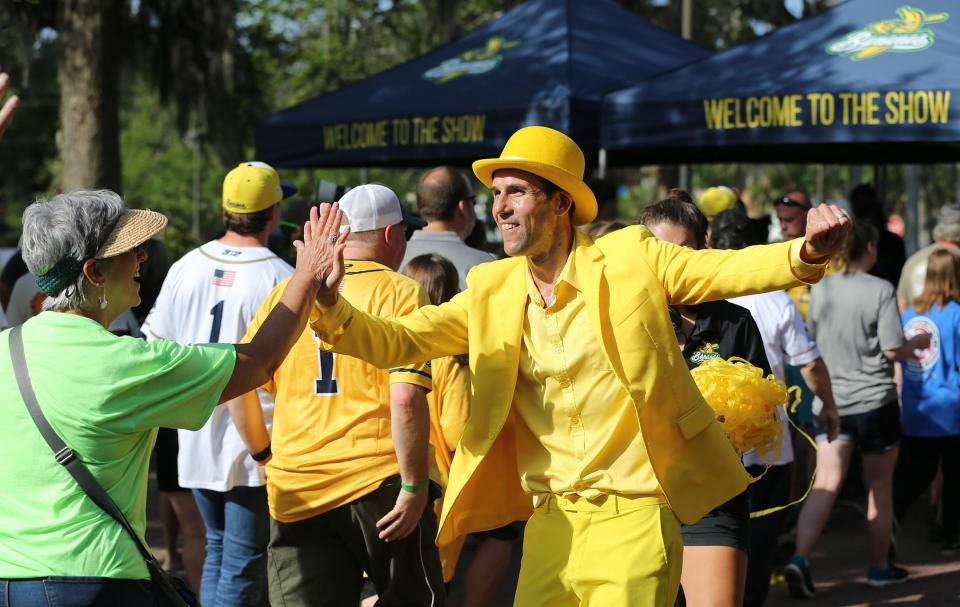 Savannah Bananas owner Jesse Cole high-fives fans as they stream into Grayson Stadium for Banana Fest on May 24.