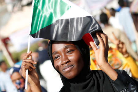 A Sudanese protester holds a national flag outside the defense ministry compound in Khartoum, Sudan, April 25, 2019. REUTERS/Umit Bektas