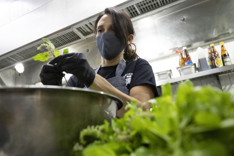 Project leader for food donations of COVID Thailand Aid, Megan Leon from Mexican prepares ingredients cooking "pad krapow gai", the spicy minced chicken for the railway-side community at Bo.lan restaurant in Bangkok Wednesday, June 10, 2020, Thailand. Thailand's Natalie Bin Narkprasert, who runs a business in Paris, was stranded in her homeland by a flight ban, so she decided to use her skills to organize a network of volunteers, including Michelin-starred chefs, to help those in her homeland whose incomes were most affected by the pandemic restrictions. (AP Photo/Sakchai Lalit)