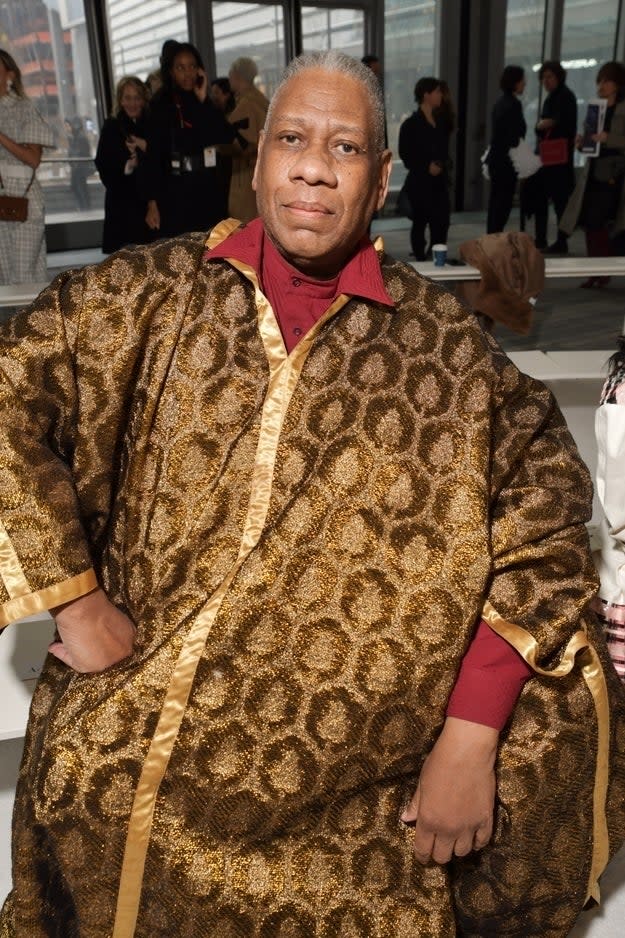 Andre Leon Talley wearing a gold-patterned robe with a red collar at an event