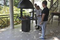 Russian President Vladimir Putin (L) and Prime Minister Dmitry Medvedev (R) watch a cook roast meat for them during breakfast at the Bocharov Ruchei state residence in Sochi, Russia, August 30, 2015. REUTERS/Michael Klimentyev/RIA Novosti/Kremlin