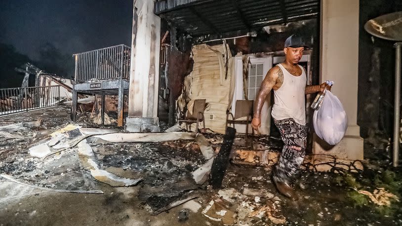 Terrell Samuels carries a bag of clothes from his burned apartment. It was the only thing he could salvage from his place. Photo: John Spink/The Atlanta Journal-Constitution.