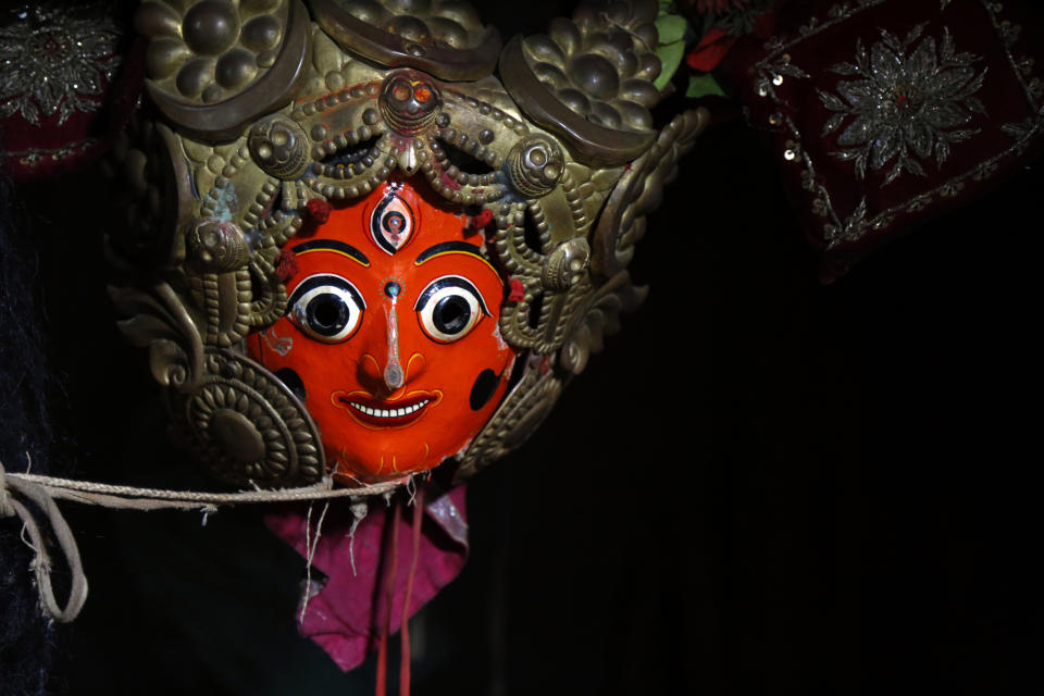 In this Oct. 16, 2018, photo, masks used for dances in Indra Jatra Festival are hung in a room at Bhaktapur, Nepal. For centuries, Nepal has celebrated the Indra Jatra festival of masked dancers, which officially begins the month-long festivities in the Hindu-dominated Himalyan nation. The dancers, who come from a variety of backgrounds, pull off this performance every year despite minimal financial support from the government and other sources, they say. (AP Photo/Niranjan Shrestha)