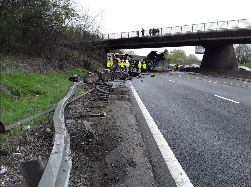 Dramatic photographs show the aftermath of a horror motorway crash which has left a lorry split in half. See SWNS story SWLNcrash; Emergency services were called to the M6 in Staffordshire following the smash involving a lorry which overturned and caught fire earlier today (Sun).  Traffic was stopped in both directions between Junction 12 for Cannock and Junction 13 for Stafford as police and ambulance crews rushed to the scene. Shocking images show how the HGV was completely split in two by the impact of the collision which also left its engine strewn across the carriageway. 