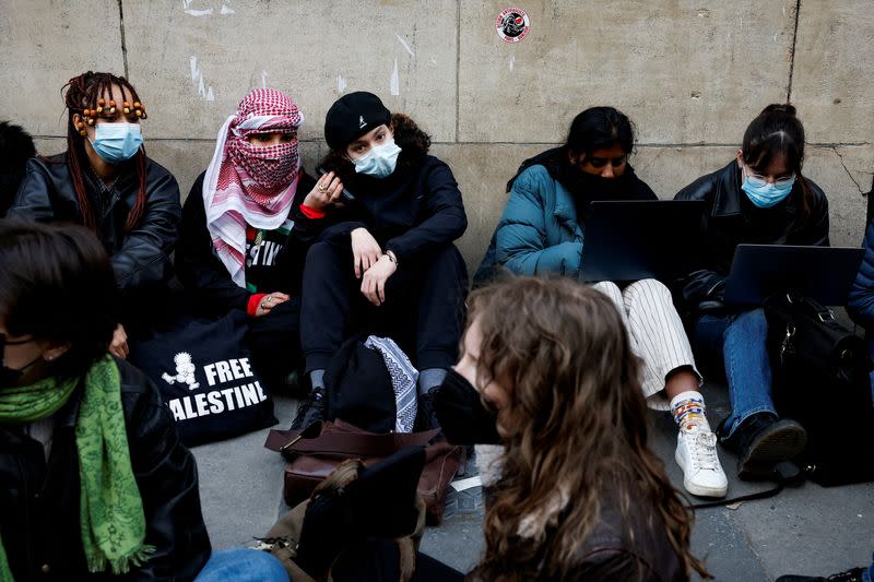 Masked youths take part in the occupation of a building of the Sciences Po University in support of Palestinians in Gaza, in Paris