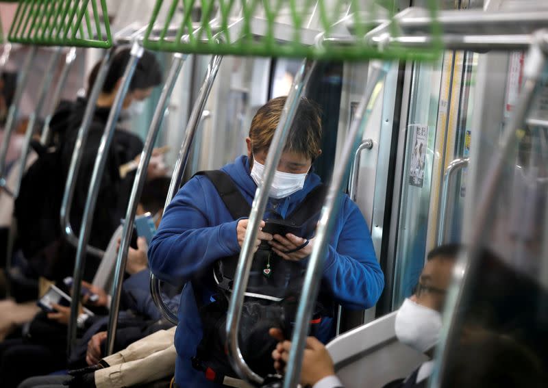 Passengers wearing protective face masks, following an outbreak of the coronavirus disease, are seen inside a train after the government announced the state of emergency for the capital following the disease outbreak in Tokyo, Japan