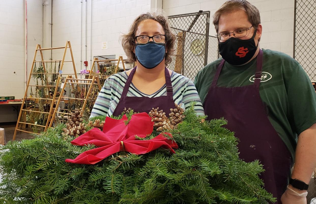 Melissa Johnson and Matt Morrissey with a hand-decorated evergreen wreath, available for purchase at Abilities Plus and the holiday open house this coming weekend.