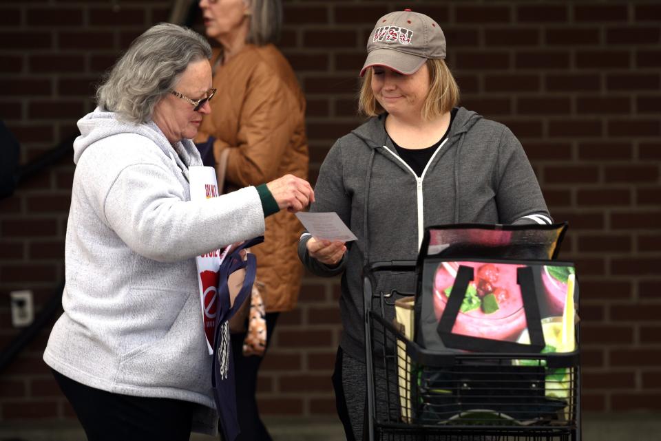 Sandy Pyle, left, who has worked at Albertsons for almost 20 years, hands a "stop the merger" leaflet to a customer, Wendy McGill, right, in front of Safeway at Port Orchard on April 5.