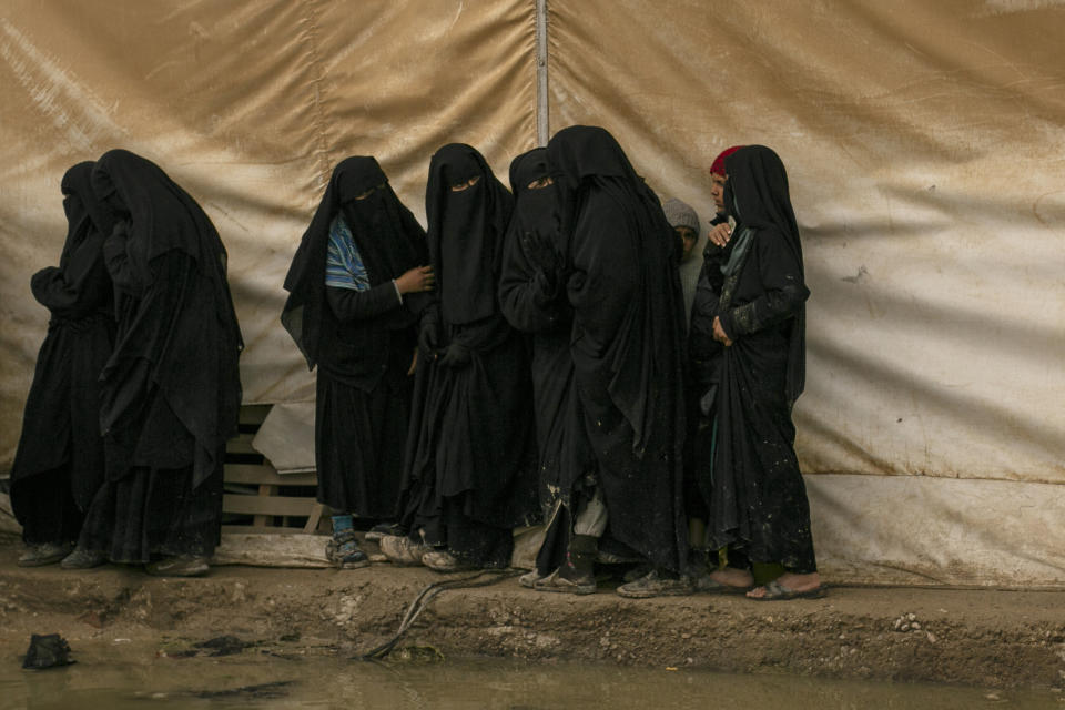 FILE - In this March 31, 2019, file, photo, women queue for aid supplies at al-Hol camp, home to Islamic State-affiliated families near Hasakeh, Syria. As Turkish troops invade northern Syria and the U.S. abandons its Kurdish allies, there are renewed fears of a prison break in the camp that could give new life to the extremist group. The Kurdish-led Syrian Democratic Forces are mobilizing to stop the Turkish invasion and say they may not be able to spare enough forces to secure al-Hol, home to tens of thousands of IS-linked women and their children. (AP Photo/Maya Alleruzzo, File)