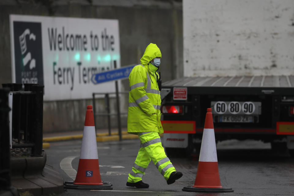 Security guard the entrance to the ferry terminal in Dover, England, Monday, Dec. 21, 2020, after the Port of Dover was closed and access to the Eurotunnel terminal suspended following the French government's announcement. France banned all travel from the UK for 48 hours from midnight Sunday, including trucks carrying freight through the tunnel under the English Channel or from the port of Dover on England's south coast. (AP Photo/Kirsty Wigglesworth)