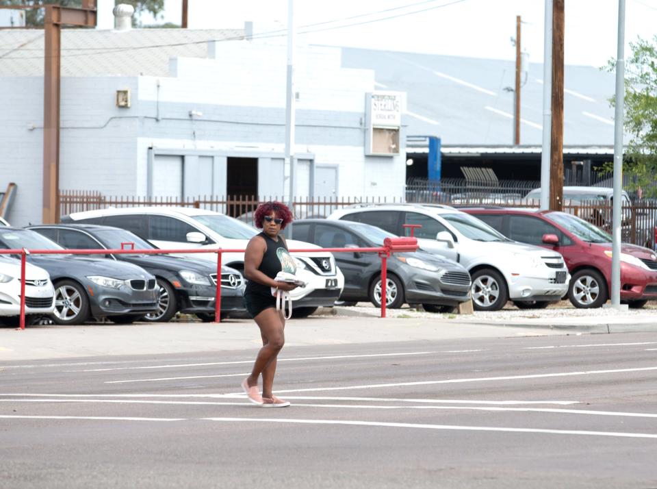 A woman crosses the street on the intersection of 51st Avenue and Camelback Road in Glendale on July 31, 2021.