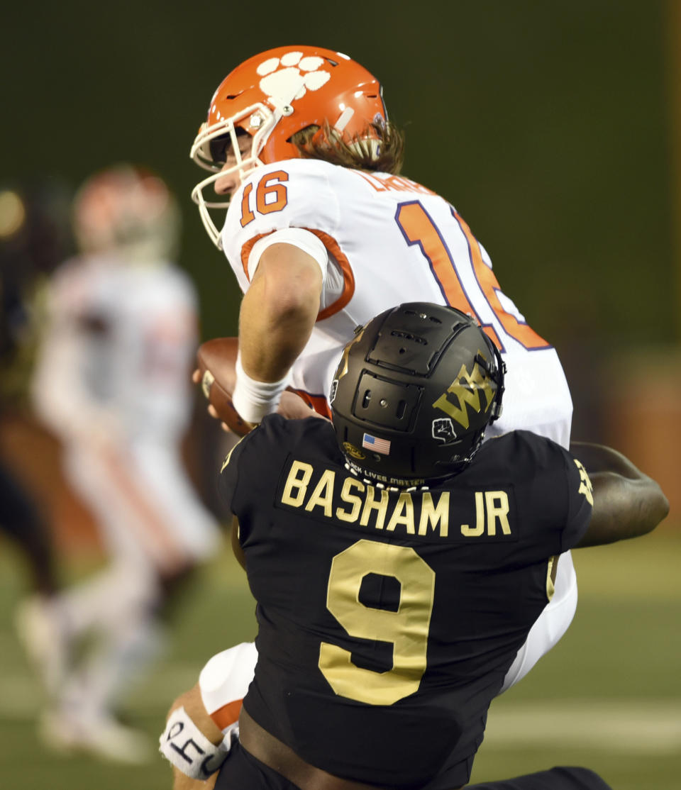 Wake Forest defensive end Carlos Basham Jr. sacks Clemson quarterback Trevor Lawrence in the first half of an NCAA college football game Saturday, Sept. 12, 2020, in Winston-Salem, N.C. (Walt Unks/The Winston-Salem Journal via AP)