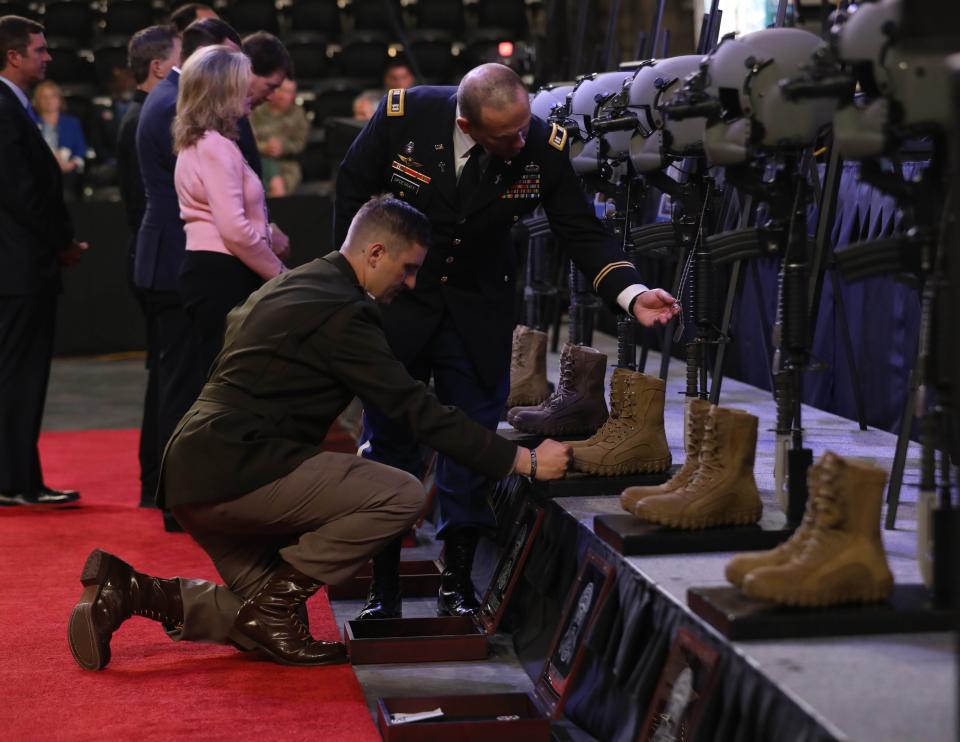 Maj. Garret Kuipers, commander of Charlie Company, 6th Battalion, 101st Combat Aviation Brigade, 101st Airborne Division (Air Assault) and Chaplain (Capt.) James Updegraff pay respects during a memorial ceremony April 13, 2023, in Clarksville, Tenn.