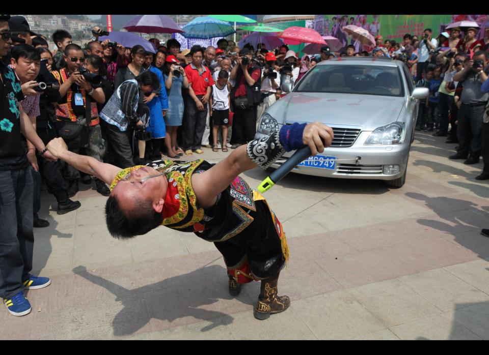 Yang Guanghe pulls a vehicle with his eye sockets in Anshun, Guizhou Province of China on April 28, 2012. Yang Guanghe dragged a 1.6 ton vehicle successfully.  