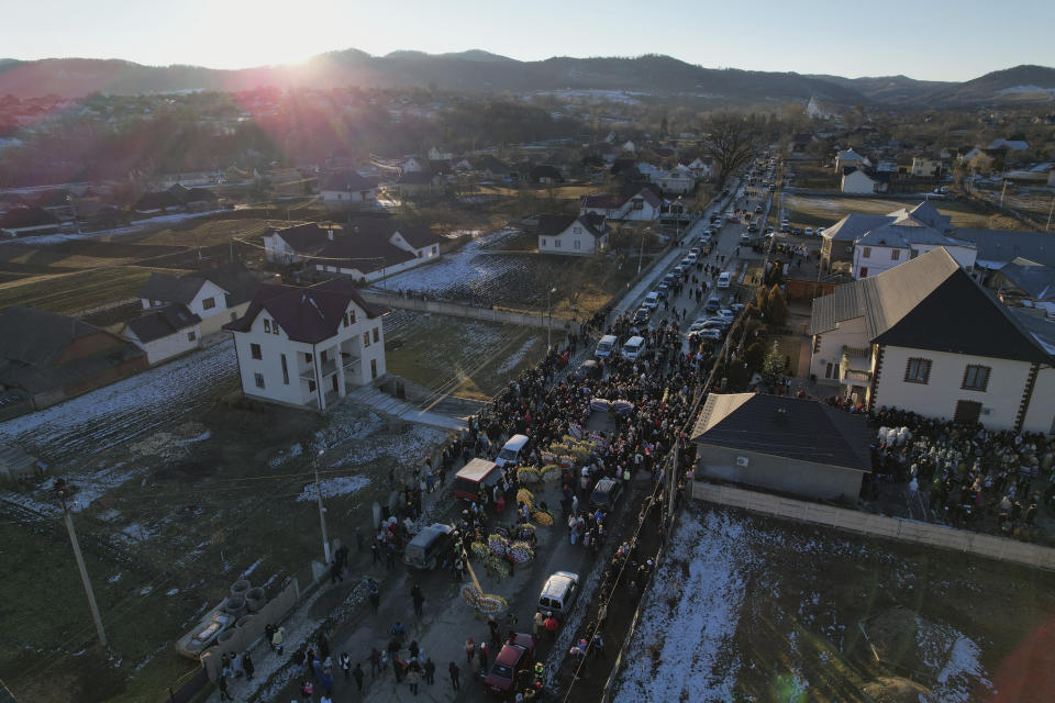 An aerial view of villagers parading the street while celebrating the Malanka festival in the village of Krasnoilsk, Ukraine, Thursday, Jan. 14, 2022. Dressed as goats, bears, oxen and cranes, many Ukrainians rang in the new year last week in the colorful rituals of the Malanka holiday. Malanka, which draws on pagan folk tales, marks the new year according to the Julian calendar, meaning it falls on Jan. 13-14. In the festivities, celebrants go from house to house, where the dwellers offer them food. (AP Photo/Ethan Swope)