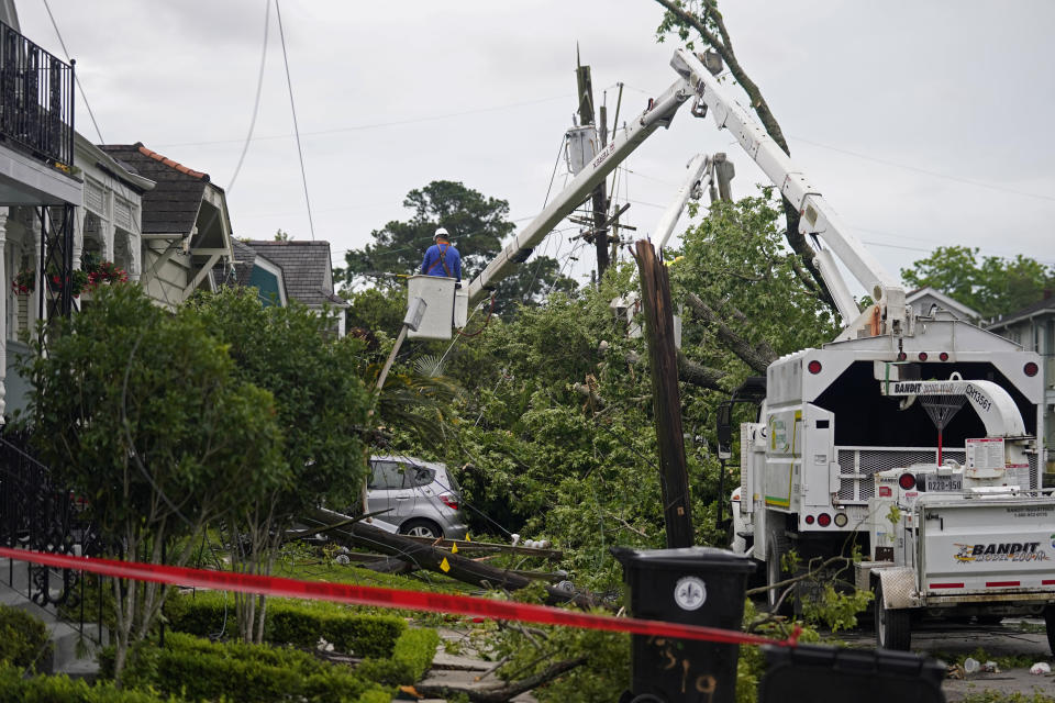 Utility workers clear a downed tree from a possible tornado after heavy storms moved through the area Tuesday night, in the Uptown section of New Orleans, Wednesday, May 12, 2021. (AP Photo/Gerald Herbert)