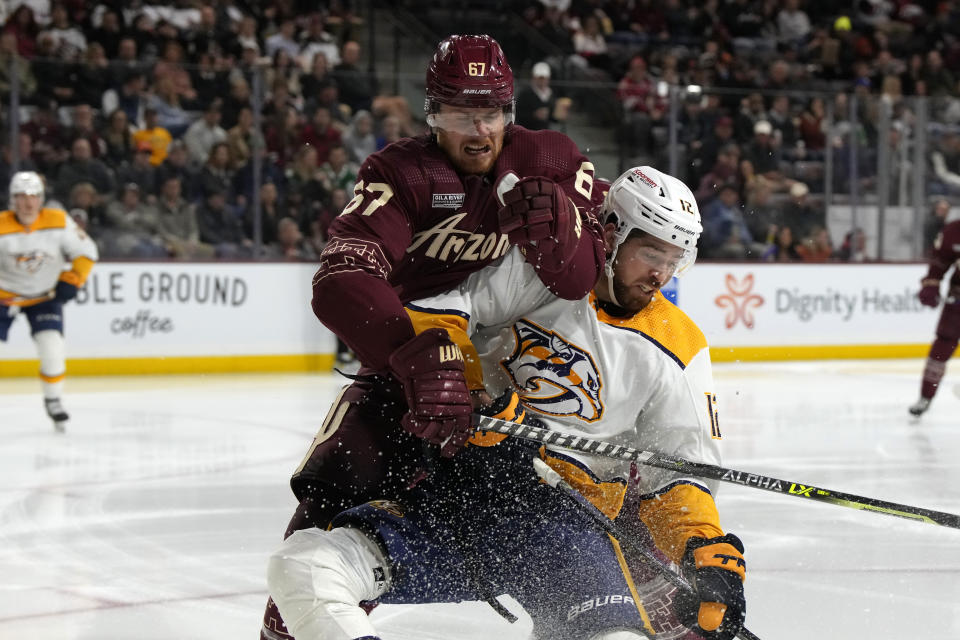 Arizona Coyotes left wing Lawson Crouse (67) and Nashville Predators left winger Zach Sanford battle for the puck in the second period during an NHL hockey game, Sunday, Feb. 26, 2023, in Tempe, Ariz. (AP Photo/Rick Scuteri)