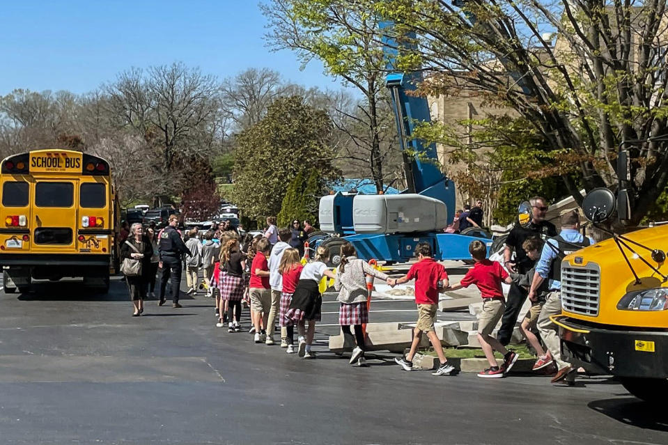 Image: Children from The Covenant School, a private Christian school in Nashville, Tenn., hold hands as they are taken to a reunification site at the Woodmont Baptist Church after a shooting at their school, on March, 27, 2023. (Jonathan Mattise / AP)