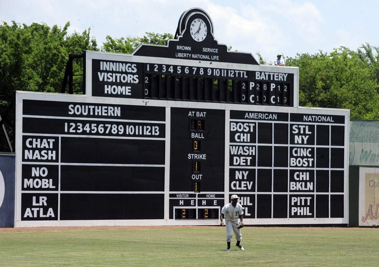 Birmingham Barons outfielder Luis Basabe moves toward a ball in front of the vintage scoreboard at Rickwood Field, America's oldest baseball park, during a Double-A game between the Barons and the Montgomery Biscuits on Wednesday, May 29, 2019, in Birmingham, Ala. Built in 1910, the ballpark predates better-known parks including Chicago's Wrigley Field and Fenway Park in Boston. (AP Photo/Jay Reeves)