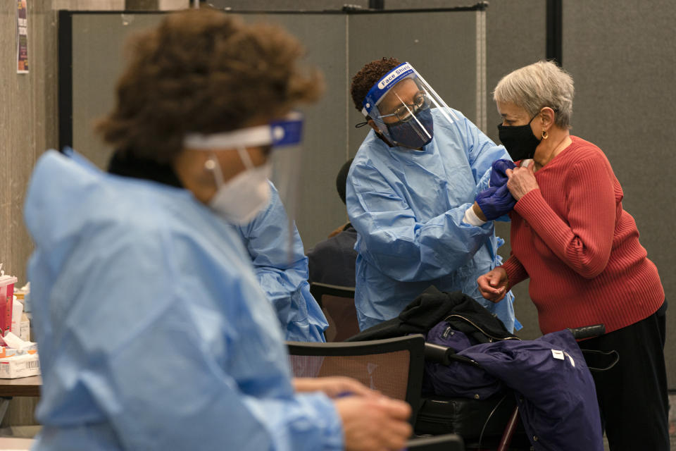 In this Thursday, Feb. 11, 2021, photo Charlotte Lee, 78, of Washington, right, prepares to receive her second dose of the COVID-19 vaccine at a clinic at Howard University, in Washington. "I have underlying conditions so I had no hesitation in getting this vaccine," says Lee, who signed up at Howard after being unsuccessful at using the city's vaccination sign-up site. (AP Photo/Jacquelyn Martin)