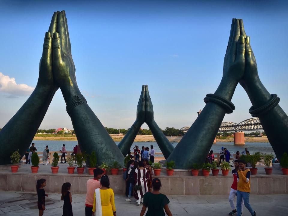 People visit the newly constructed Namo Ghat with giant sculptures of praying hands on the banks of river Ganges in Varanasi.