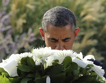 U.S. President Barack Obama pauses before a wreath before remembrance ceremonies for 9/11 victims at the Pentagon 9/11 Memorial in Washington September 11, 2013. REUTERS/Gary Cameron