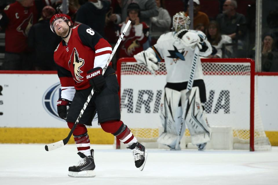 Arizona Coyotes right wing Phil Kessel, left, watches his goal against San Jose Sharks goaltender Aaron Dell, right, on the scoreboard screen during the first period of an NHL hockey game Tuesday, Jan. 14, 2020, in Glendale, Ariz. (AP Photo/Ross D. Franklin)