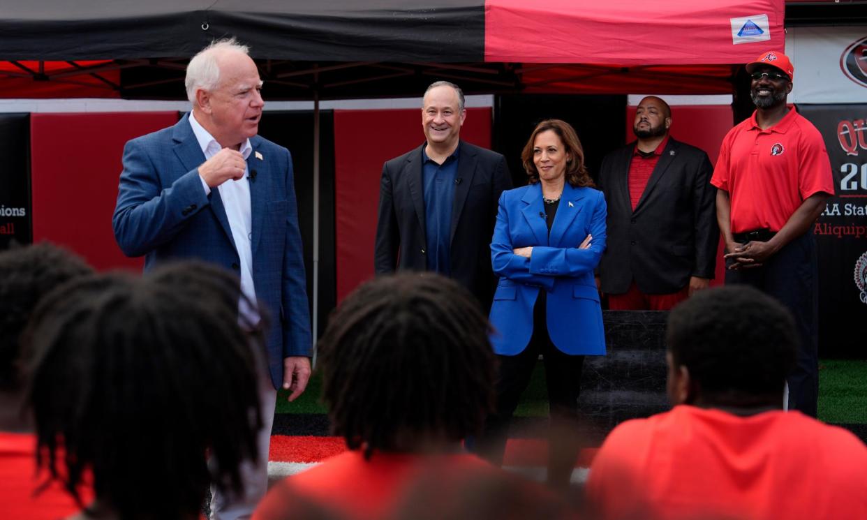 <span>Democratic vice-presidential nominee Tim Walz, from left, speaks as second gentleman Doug Emhoff and Democratic presidential nominee Kamala Harris listen during a campaign stop greeting members of the Aliquippa high school football team on Sunday.</span><span>Photograph: Julia Nikhinson/AP</span>