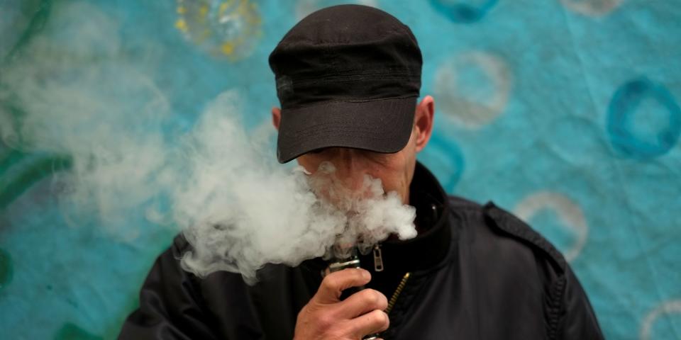 Man vaping/vapes