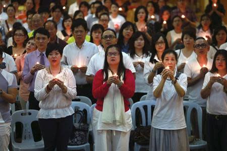 Malaysians hold candles during a special prayer for passengers onboard the missing Malaysia Airlines Flight MH370 at the Chinese Assembly Hall in Kuala Lumpur March 19, 2014. REUTERS/Samsul Said