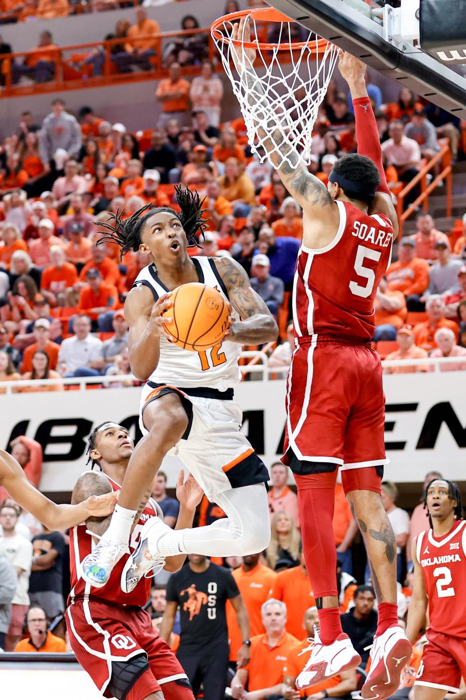 Oklahoma State guard Javon Small (12) jumps to lay up the ball past Oklahoma guard Rivaldo Soares (5) in the second half during an NCAA basketball game between Oklahoma and Oklahoma State in Stillwater, Okla., on Saturday, Feb. 24, 2024.