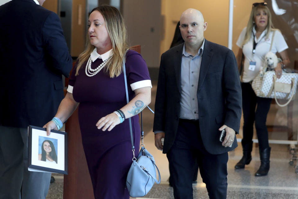 Lori Alhadeff, holding a photo of her daughter Alyssa, and her husband Ilan Alhadeff walk into court during the sentencing hearing for Marjory Stoneman Douglas High School shooter Nikolas Cruz at the Broward County Courthouse in Fort Lauderdale, Fla., on Wednesday, Nov. 2, 2022. Cruz was sentenced to life in prison for murdering 17 people at Parkland's Marjory Stoneman Douglas High School more than four years ago. (Mike Stocker/South Florida Sun Sentinel via AP, Pool)