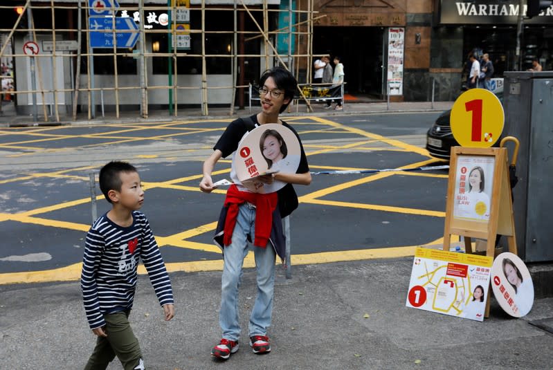 A man campaigns for candidate Susi Law ahead of district council elections in Hong Kong