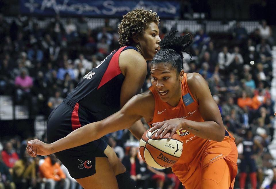 Connecticut Sun's Alyssa Thomas, front, drives past Washington Mystics' Tianna Hawkins during the first half in Game 4 of basketball's WNBA Finals, Tuesday, Oct. 8, 2019, in Uncasville, Conn. (AP Photo/Jessica Hill)