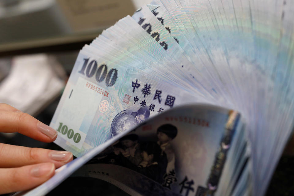 A teller counts New Taiwan dollar (TWD) $1000 banknotes at a bank in Taipei, Taiwan February 23, 2017.  Picture taken February 23, 2017. REUTERS/Tyrone Siu