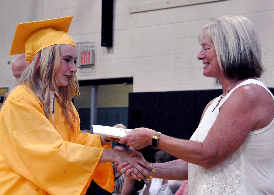 Rhegan Pompey (left) receives her diploma from Valorie Lewis, the president of the Southeast Local Schools Board of Education, during her graduation ceremony on Saturday, May 21. Waynedale High School Principal Richard Roth said being able to hug and shake the hands of graduates was a highlight of this year's ceremony.