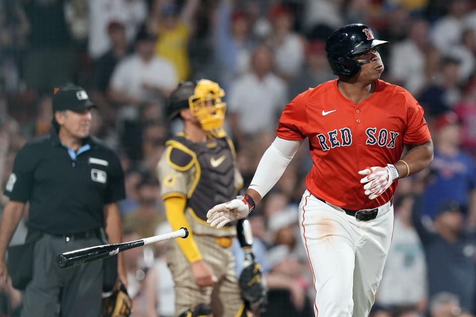 Boston Red Sox's Rafael Devers, right, watches his solo home run in front of San Diego Padres catcher Kyle Higashioka, center, during the sixth inning of a baseball game, Friday, June 28. 2024, in Boston. (AP Photo/Michael Dwyer)