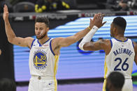 Golden State Warriors' Stephen Curry (30) and Kent Bazemore (26) celebrate before being substituted out of the game in the second half of an NBA basketball game against the Cleveland Cavaliers, Thursday, April 15, 2021, in Cleveland. The Warriors won 119-101. (AP Photo/David Dermer)