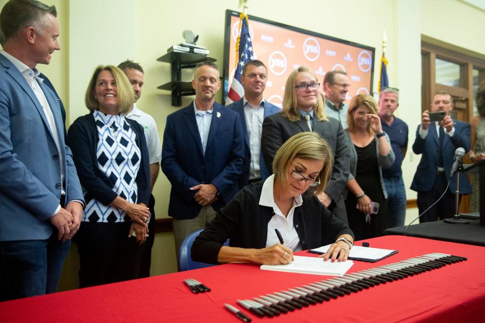 Gov. Kim Reynolds signs a sweeping tax cut package that cuts income and property taxes, eliminates the inheritance tax and realigns the state's mental health funding system, on Wednesday, June, 16, 2021, at YSS, in Ames. 