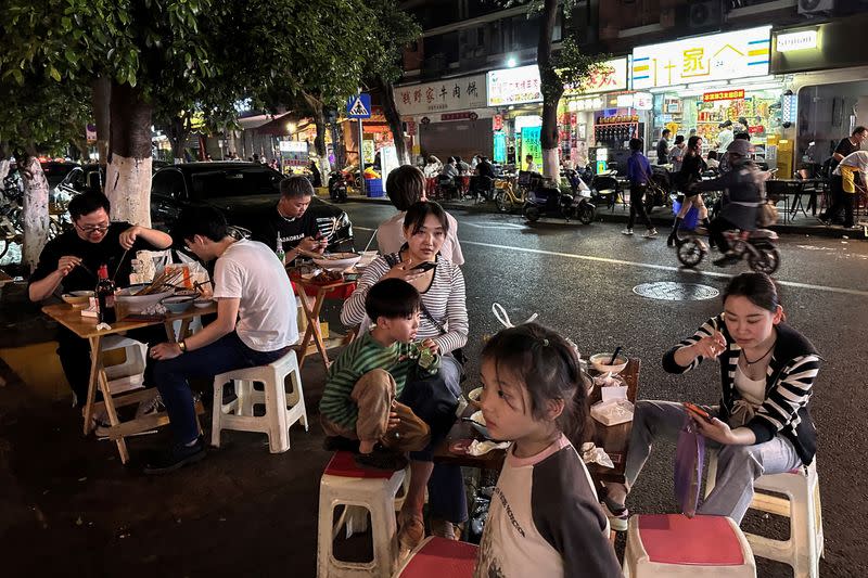 People dine near restaurant by a street in Chengdu