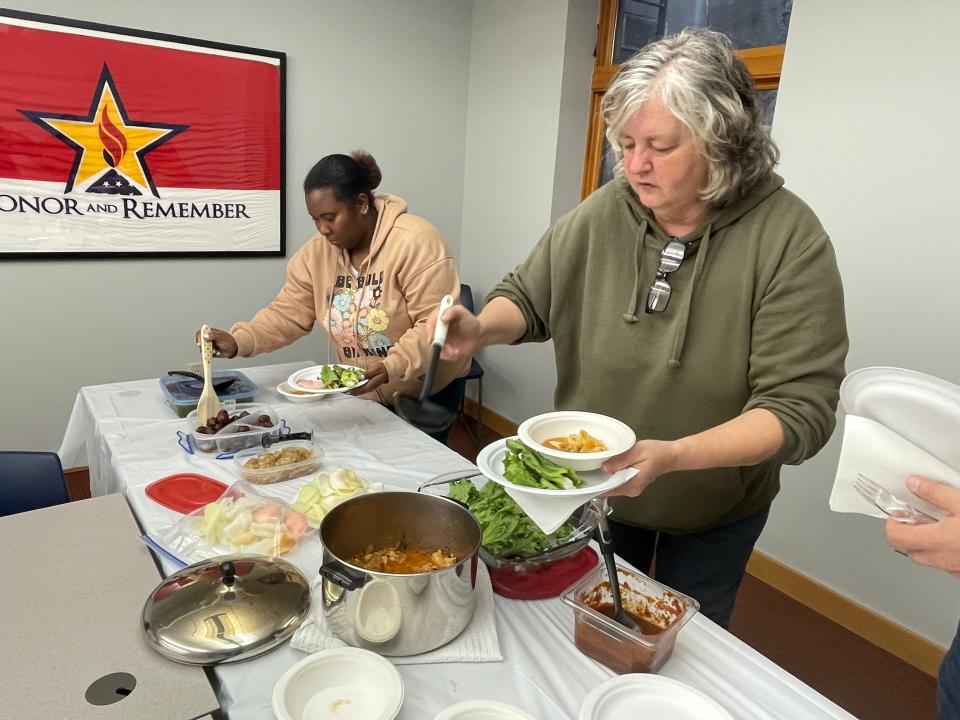 Norwich residents Allana Holmes and Karen Carignan serve themselves at Otis Library's Cultural Cooking Club Wednesday. Attendees brought two soups, meatballs, leaf wraps, shrimp crackers and candied ginger.