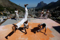 Members of the Acorda Capoeira (Awaken Capoeira) group perform on a rooftop in the Rocinha favela in Rio de Janeiro, Brazil, July 24, 2016. REUTERS/Bruno Kelly