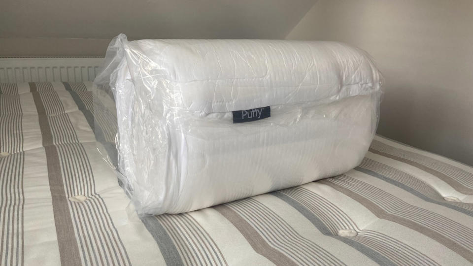 Puffy Deluxe Mattress Topper rolled up in plastic