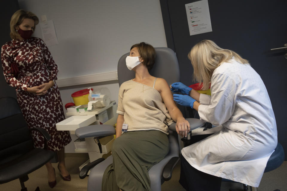 Belgium's Queen Mathilde, left speaks with a volunteer, center, as she receives an injection at the Center for the Evaluation of Vaccinations (CEV) in Antwerp, Belgium, Wednesday, Sept. 23, 2020. Belgium's Queen Mathilde on Wednesday visited the vaccine trial unit at the center to speak with volunteers participating in a COVID-19 vaccine study. (AP Photo/Virginia Mayo)