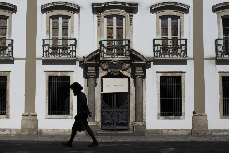 This Sept. 5, 2012 photo shows a man walking past the Paco Imperial or Royal Palace, the home where the Portuguese royal family settled when they fled Europe just ahead of Napoleon's advancing troops in Rio de Janeiro. (AP Photo/Felipe Dana)