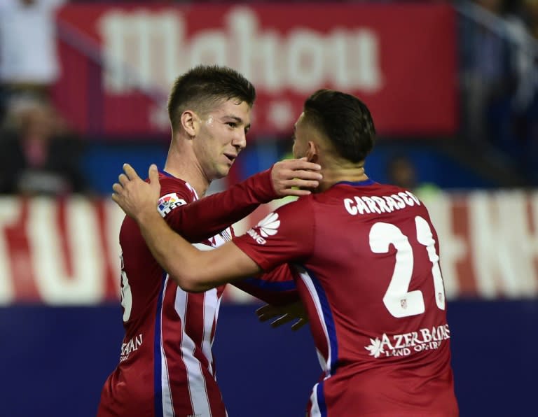 Atletico Madrid's Luciano Vietto (L) celebrates with teammate Yannick Ferreira Carrasco after scoring a goal during their Spanish La Liga match against Real Madrid, at the Vicente Calderon stadium in Madrid, on October 4, 2015